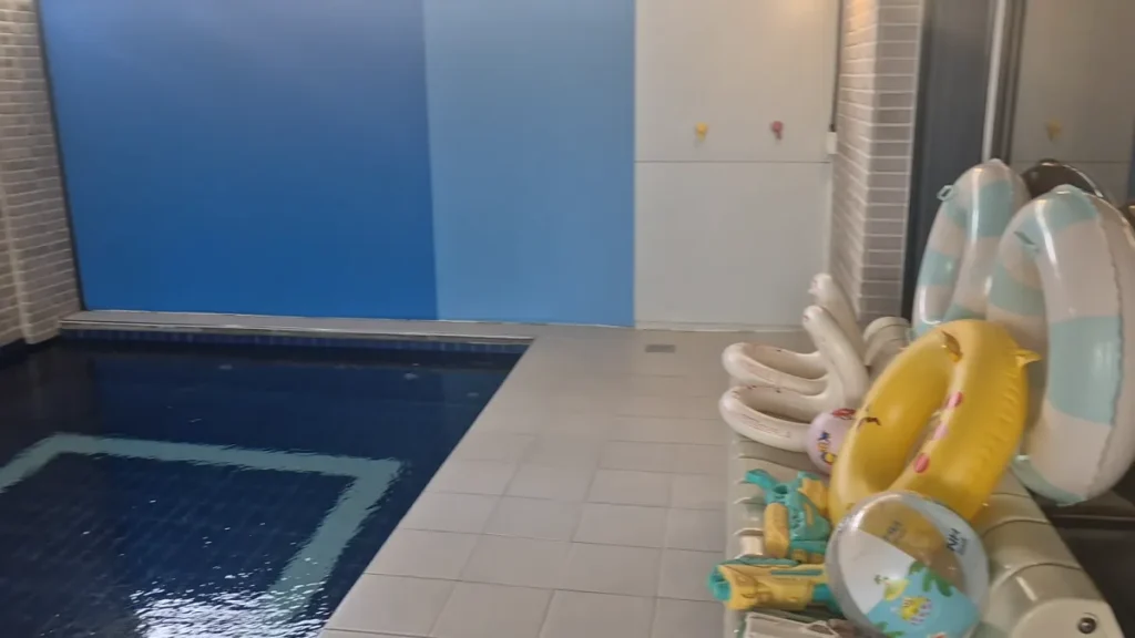 An indoor swimming pool at a Korean pension with pool floats and water toys.